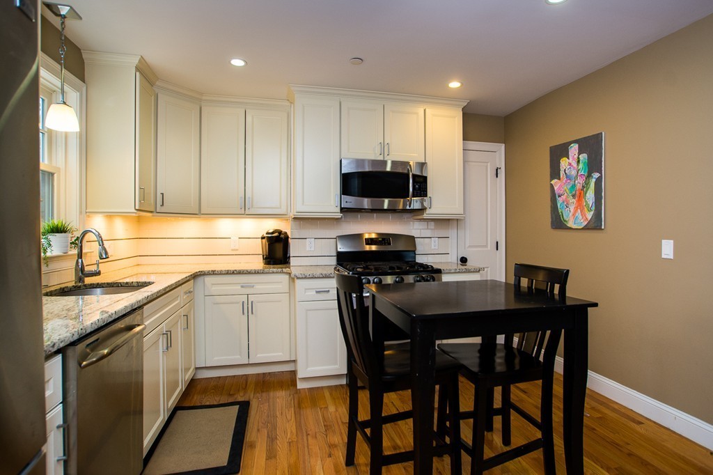 45 Selkirk Road, Unit C Boston, MA 02135 - Photo 8 of 19 a kitchen with a stove a sink a microwave a dining table and chairs