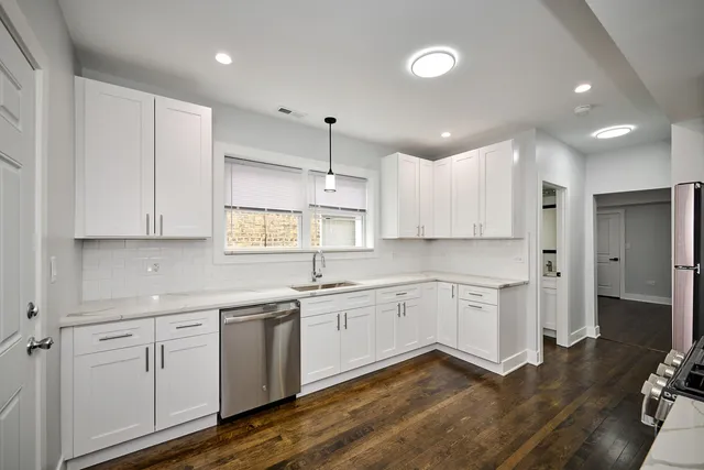 a kitchen with white cabinets appliances and a sink