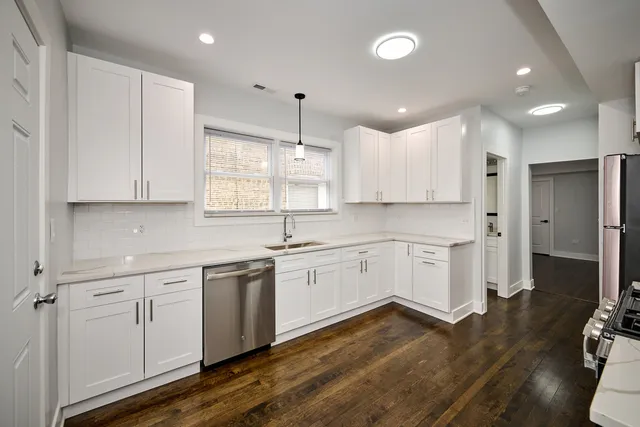 a large kitchen with cabinets wooden floor and stainless steel appliances