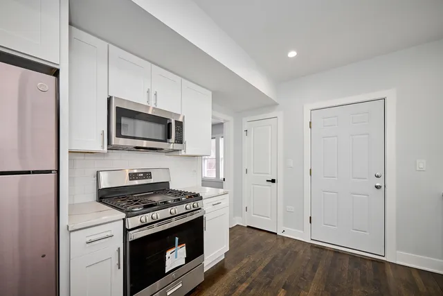 a kitchen with stainless steel appliances a white cabinet and a stove top oven