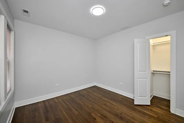 an empty room with wooden floor and closet