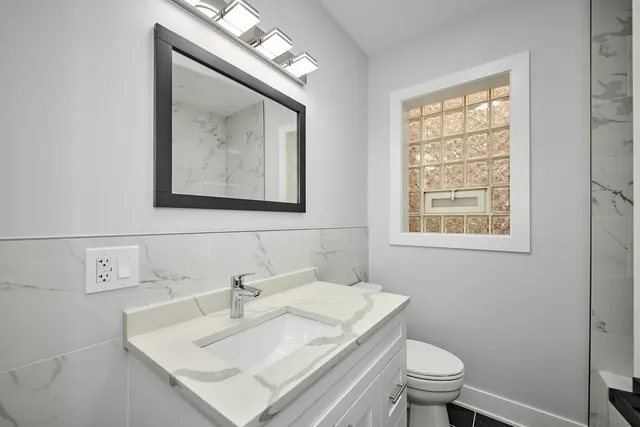 a bathroom with a sink mirror and toilet