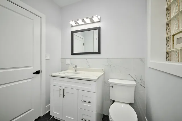 a bathroom with a toilet a sink and mirror