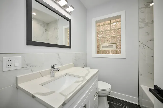 a bathroom with a toilet a sink and mirror