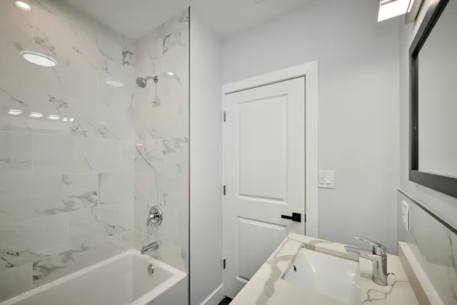 a bathroom with a tub a sink and a shower