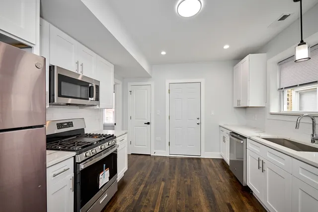 a kitchen with a sink stove top oven and cabinets