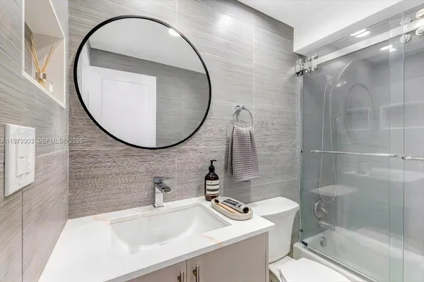 a bathroom with a sink a toilet and a mirror