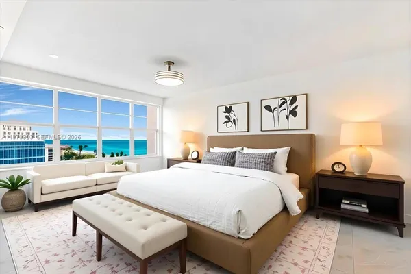 a bedroom with a bed a couch and a window