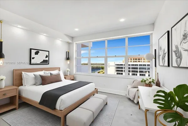 a bedroom with furniture and a large window