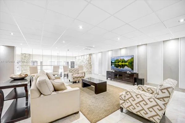 a living room with furniture a flat screen tv and a large window
