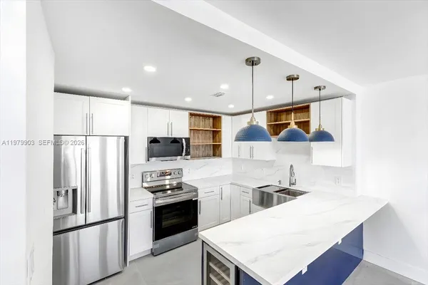 a kitchen with stainless steel appliances a refrigerator and a stove top oven