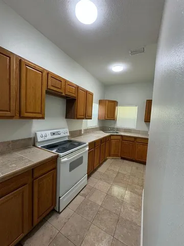 a kitchen with stainless steel appliances granite countertop a sink stove and cabinets