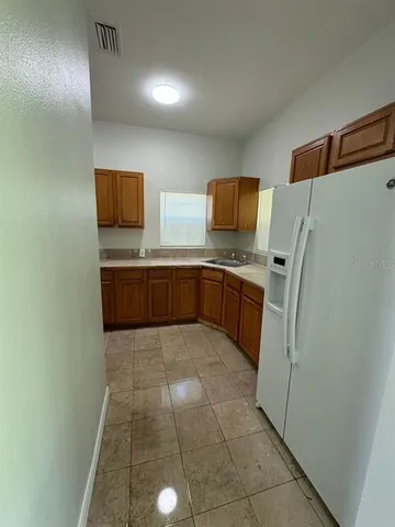 a view of an empty room and chandelier fan