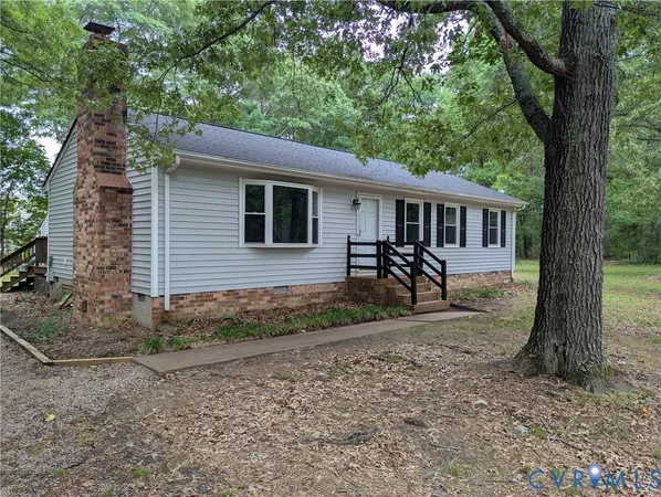 a view of a house with backyard and a tree