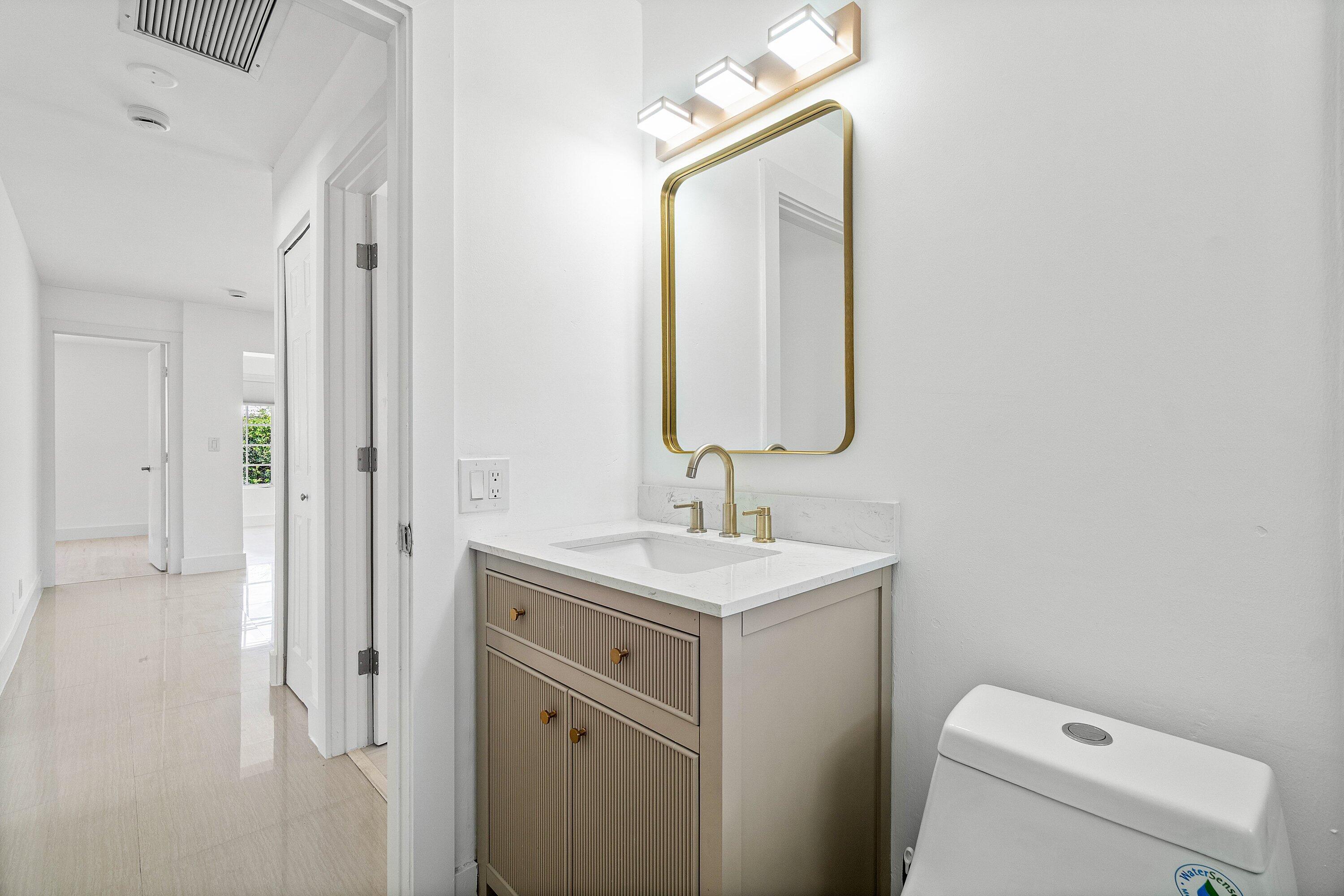 1531 Northwest 4th Street Boca Raton, FL 33486 - Photo 24 of 34 a bathroom with a toilet sink and mirror