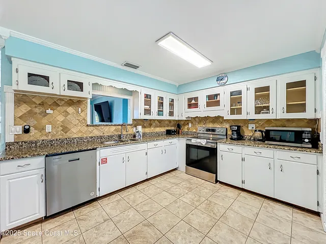 a kitchen with stainless steel appliances granite countertop a stove and cabinets