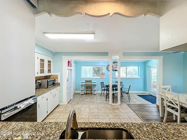 a living room with furniture a dining table and chairs with kitchen view