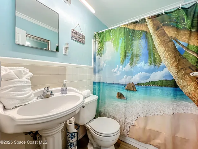 a bathroom with a toilet sink and mirror