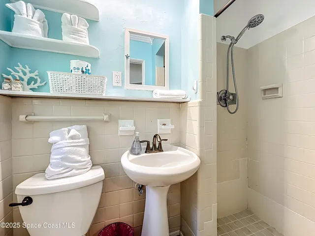 a bathroom with a sink toilet and mirror