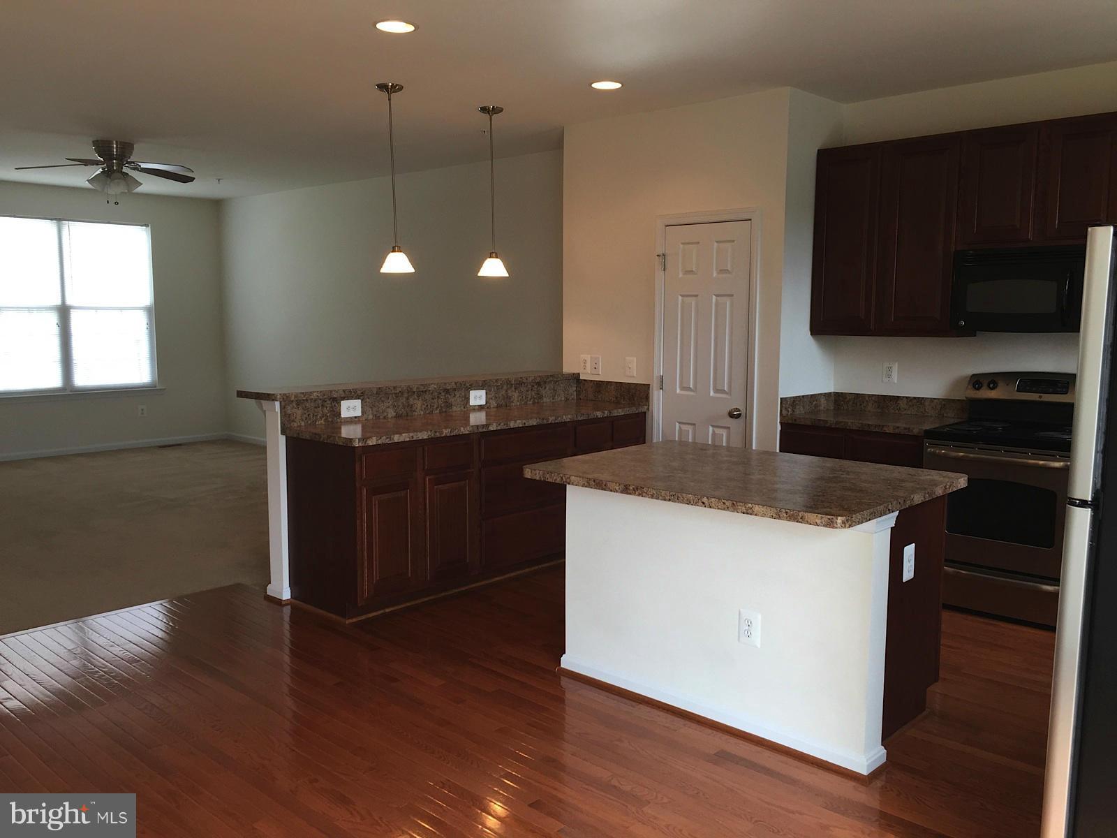 74 Backstretch Way Prince Frederick, MD 20678 - Photo 4 of 21 a kitchen with granite countertop a stove and a wooden floor