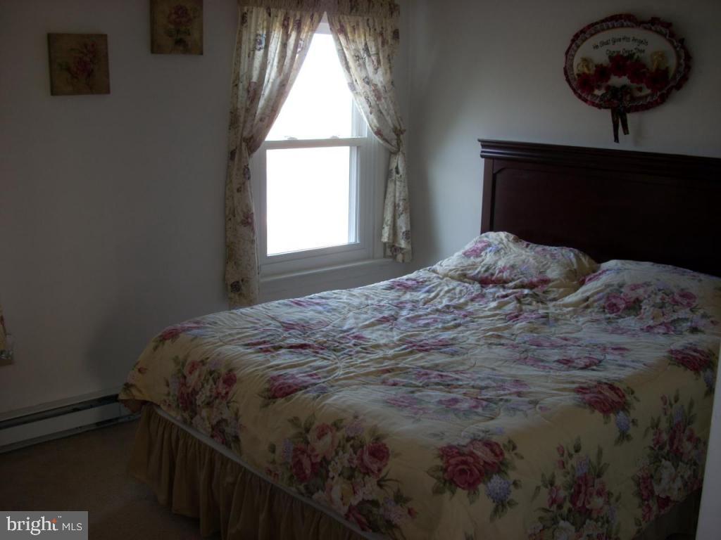 152 April Lane, Unit 17543 Lititz, PA 17543 - Photo 5 of 9 a bedroom with a bed window and a chandelier