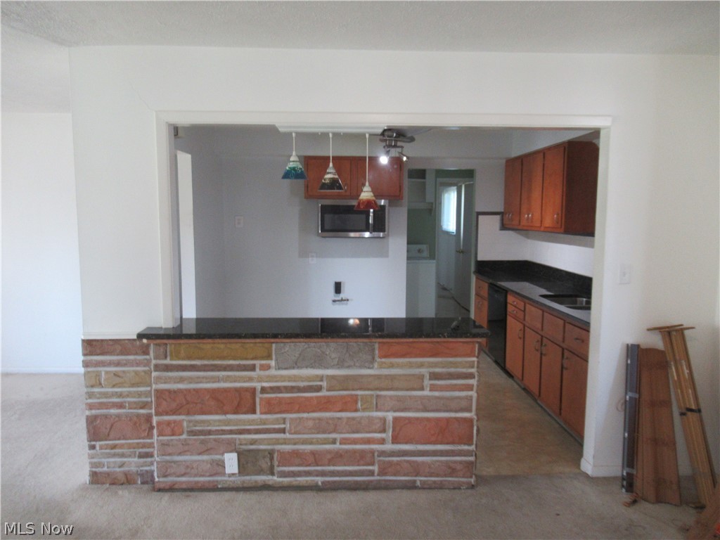 6033 Randy Road Bedford Heights, OH 44146 - Photo 8 of 19 Kitchen pass-through featuring a stone-clad breakfast bar with a dark countertop