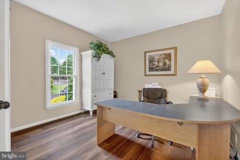 a view of a workspace with furniture and a window