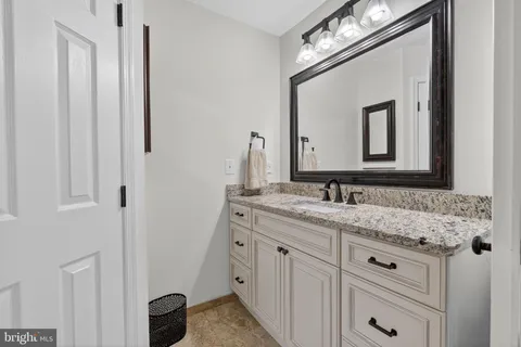 a bathroom with a sink vanity and a mirror