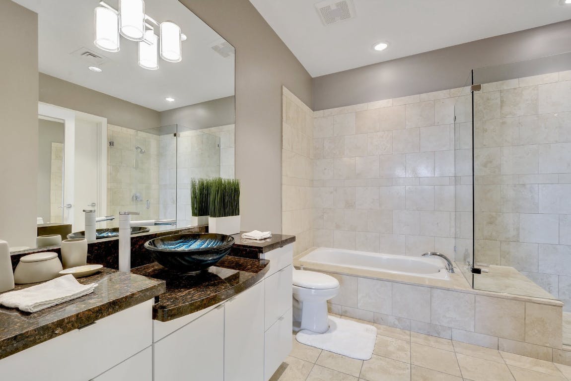 555 East 5th Street, Unit 723 Austin, TX 78701 - Photo 13 of 18 a bathroom with a granite countertop sink a toilet and bathtub