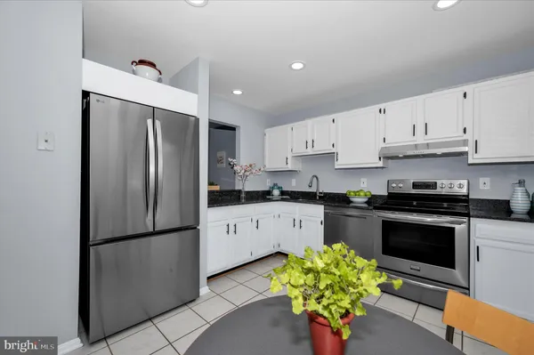 a kitchen with stainless steel appliances a refrigerator sink and a white cabinets