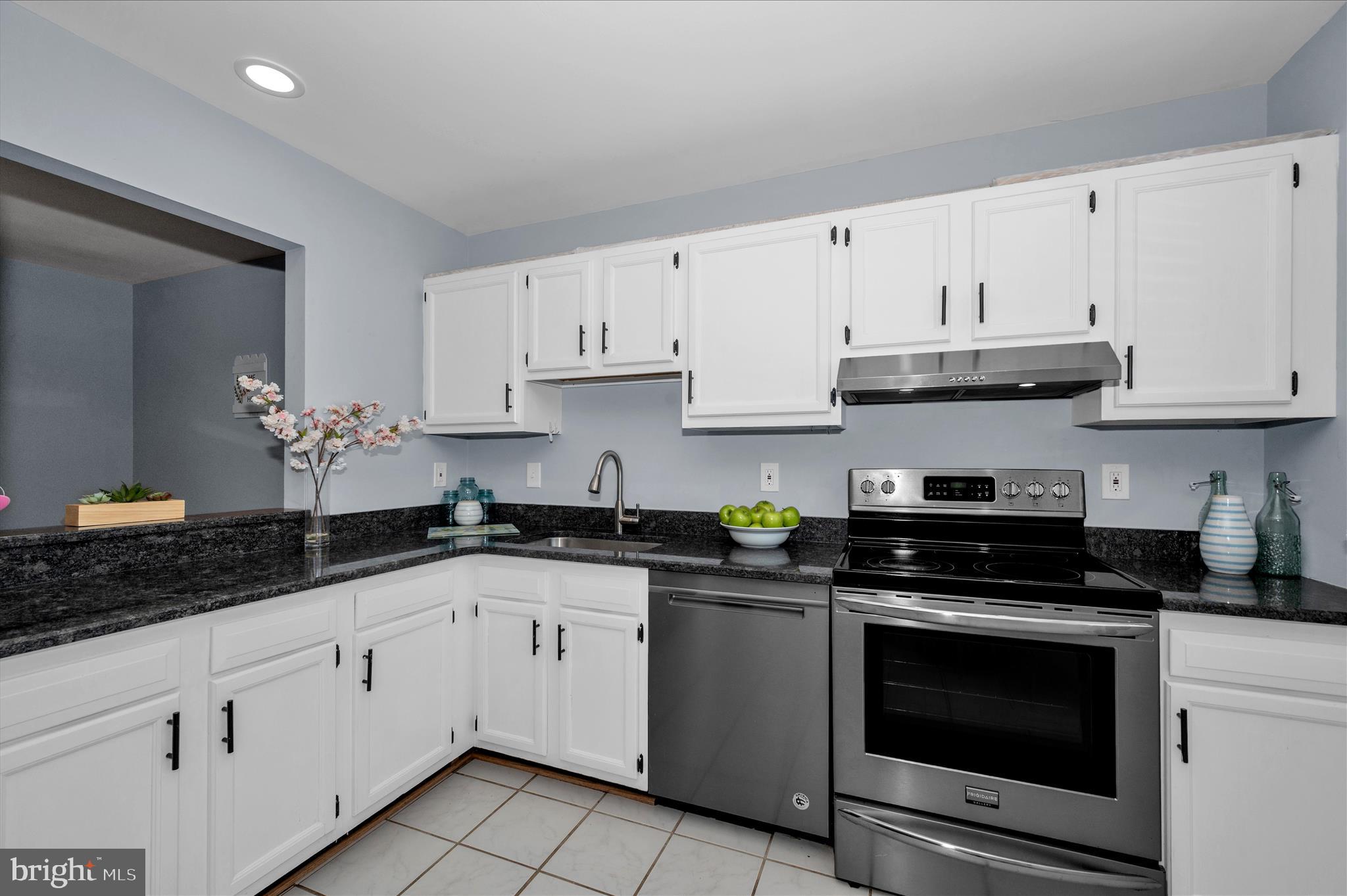 10120 Nightingale Street Gaithersburg, MD 20882 - Photo 17 of 56 a kitchen with granite countertop white cabinets white appliances