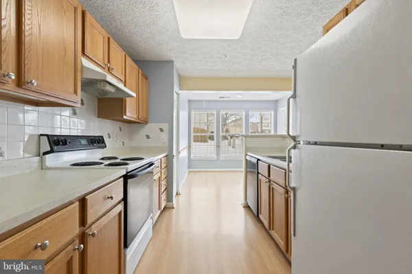 a kitchen with stainless steel appliances granite countertop a stove and a refrigerator