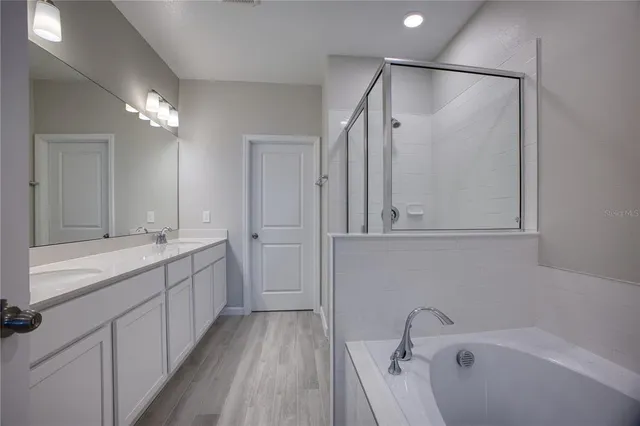 a bathroom with a tub a sink and mirrors
