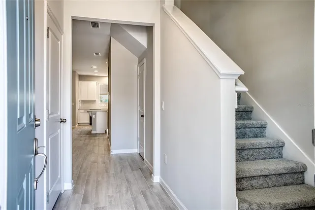 a view of a hallway with wooden floor and entryway