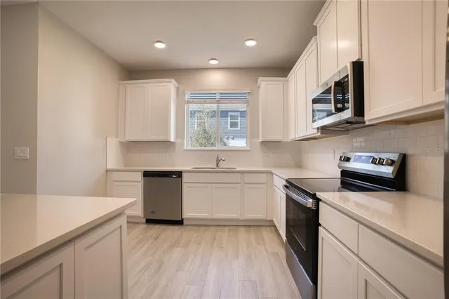 a kitchen with stainless steel appliances granite countertop a sink stove and microwave