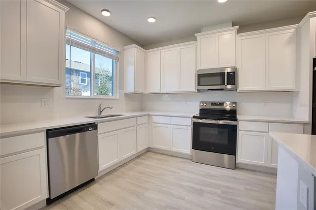 a kitchen with granite countertop a sink and steel appliances