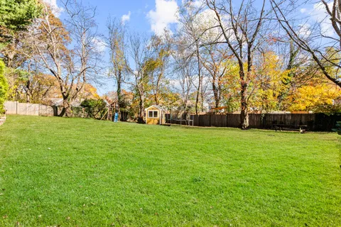 a view of a patio with table and chairs with wooden floor and fence