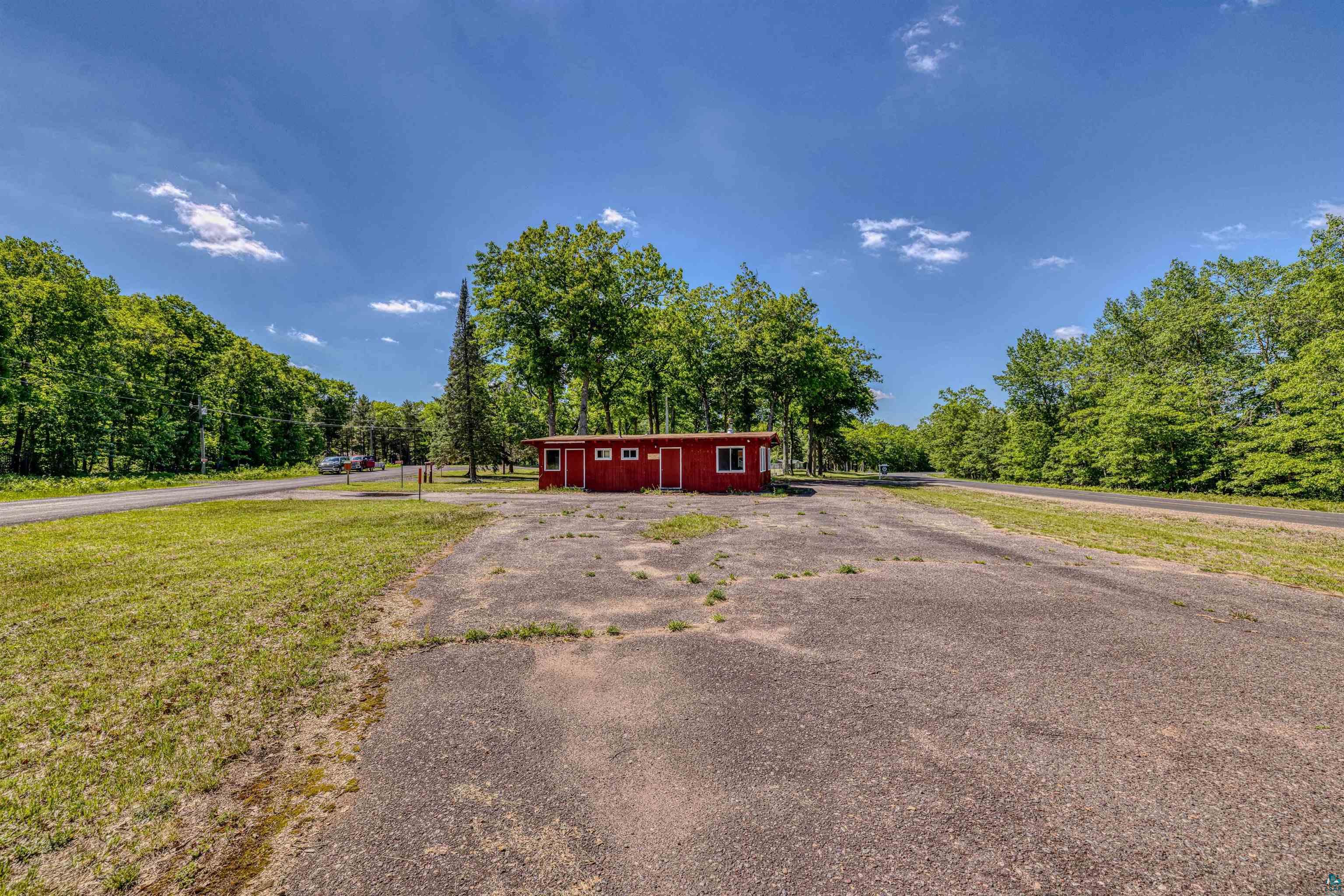66075 Rooster Road Iron River, WI 54847 - Photo 50 of 52 Red-sided structure with multiple windows, surrounded by a paved surface