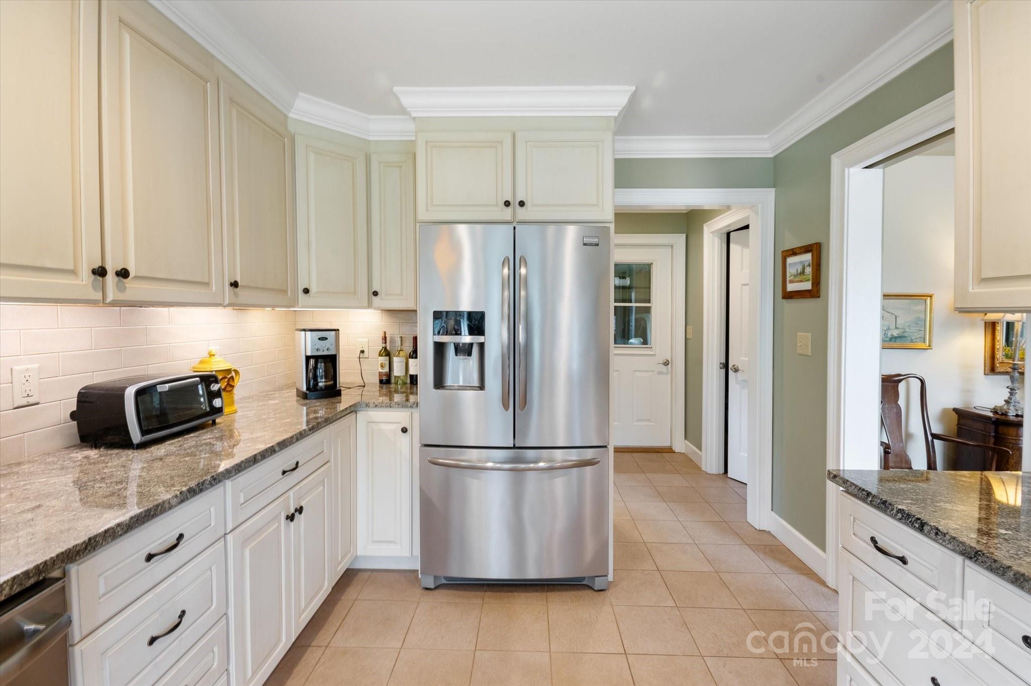 990 Club Road Tryon, NC 28782 - Photo 11 of 30 a kitchen with granite countertop a refrigerator sink and cabinets
