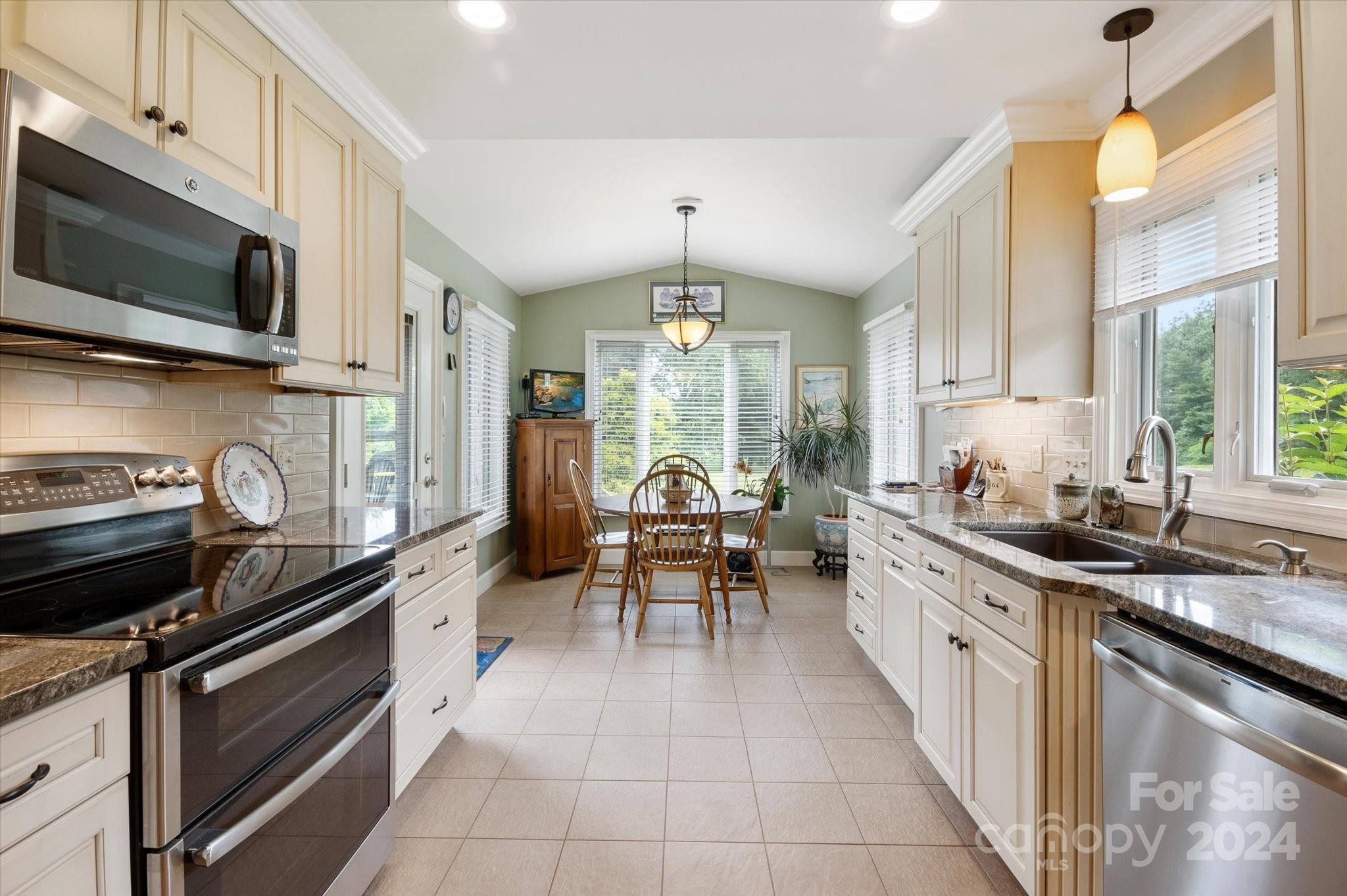 990 Club Road Tryon, NC 28782 - Photo 12 of 30 a kitchen with stainless steel appliances a stove sink microwave and cabinets