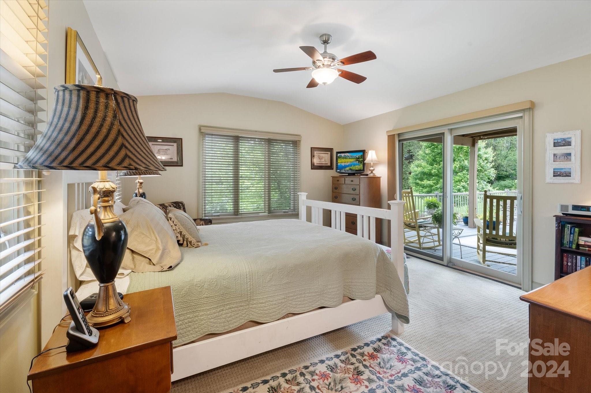 990 Club Road Tryon, NC 28782 - Photo 23 of 30 a bedroom with a bed a chandelier and a window