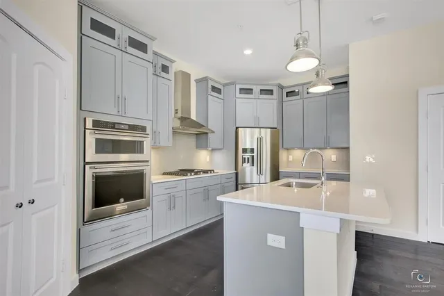 a kitchen with stainless steel appliances a refrigerator sink and stove
