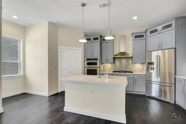 a kitchen with kitchen island a counter top space stainless steel appliances and a window
