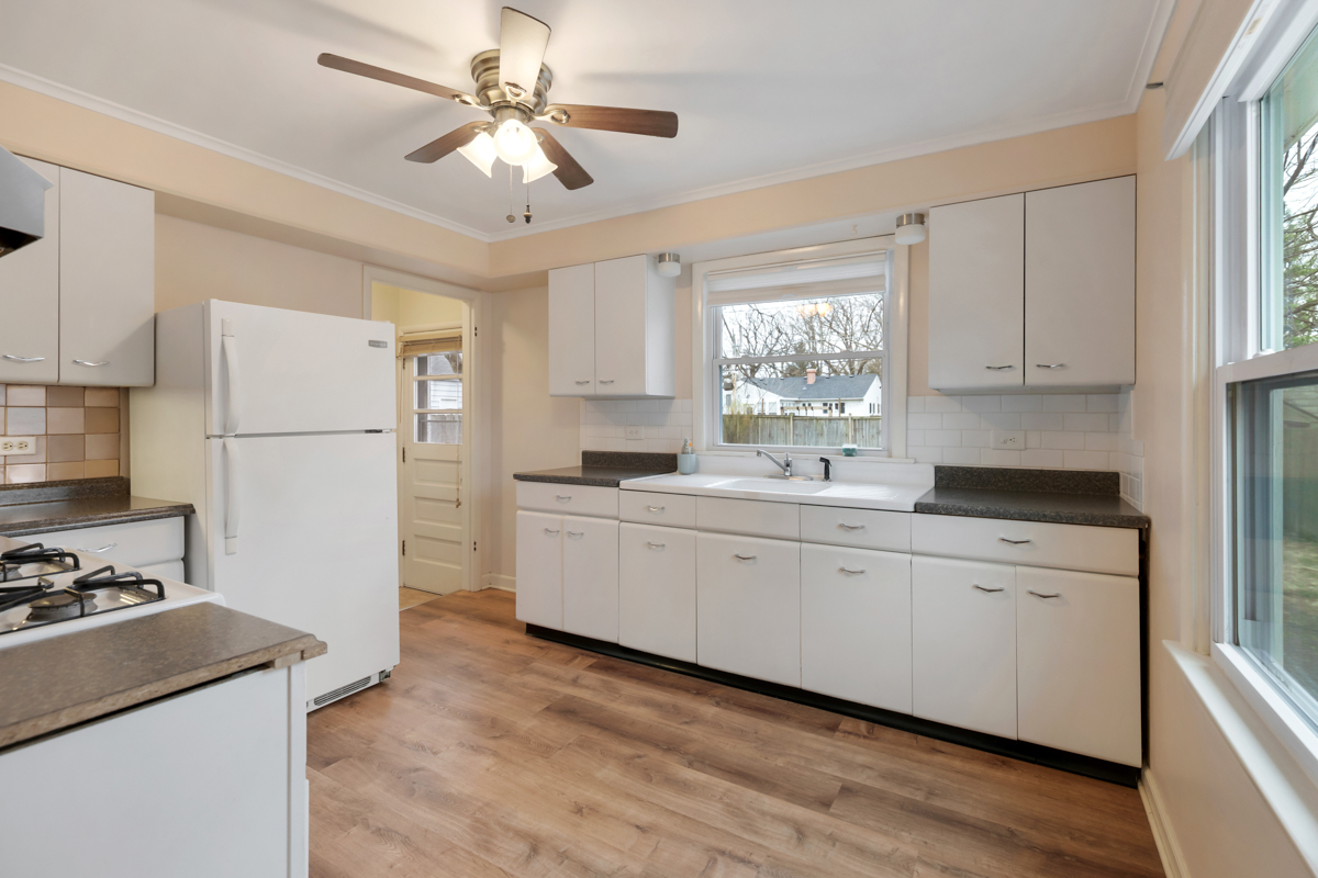 610 High Street Geneva, IL 60134 - Photo 5 of 18 a kitchen with a refrigerator a sink dishwasher a stove and white cabinets with wooden floor
