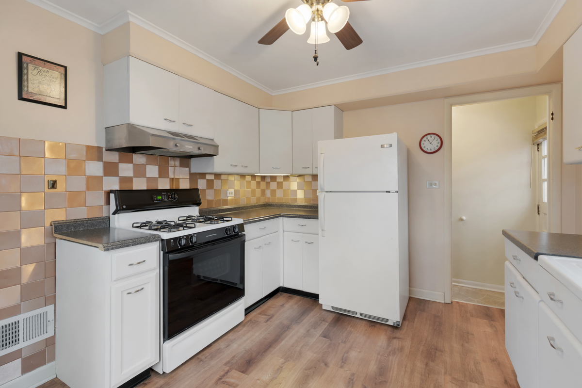610 High Street Geneva, IL 60134 - Photo 6 of 18 a kitchen with a stove a refrigerator and a white cabinets