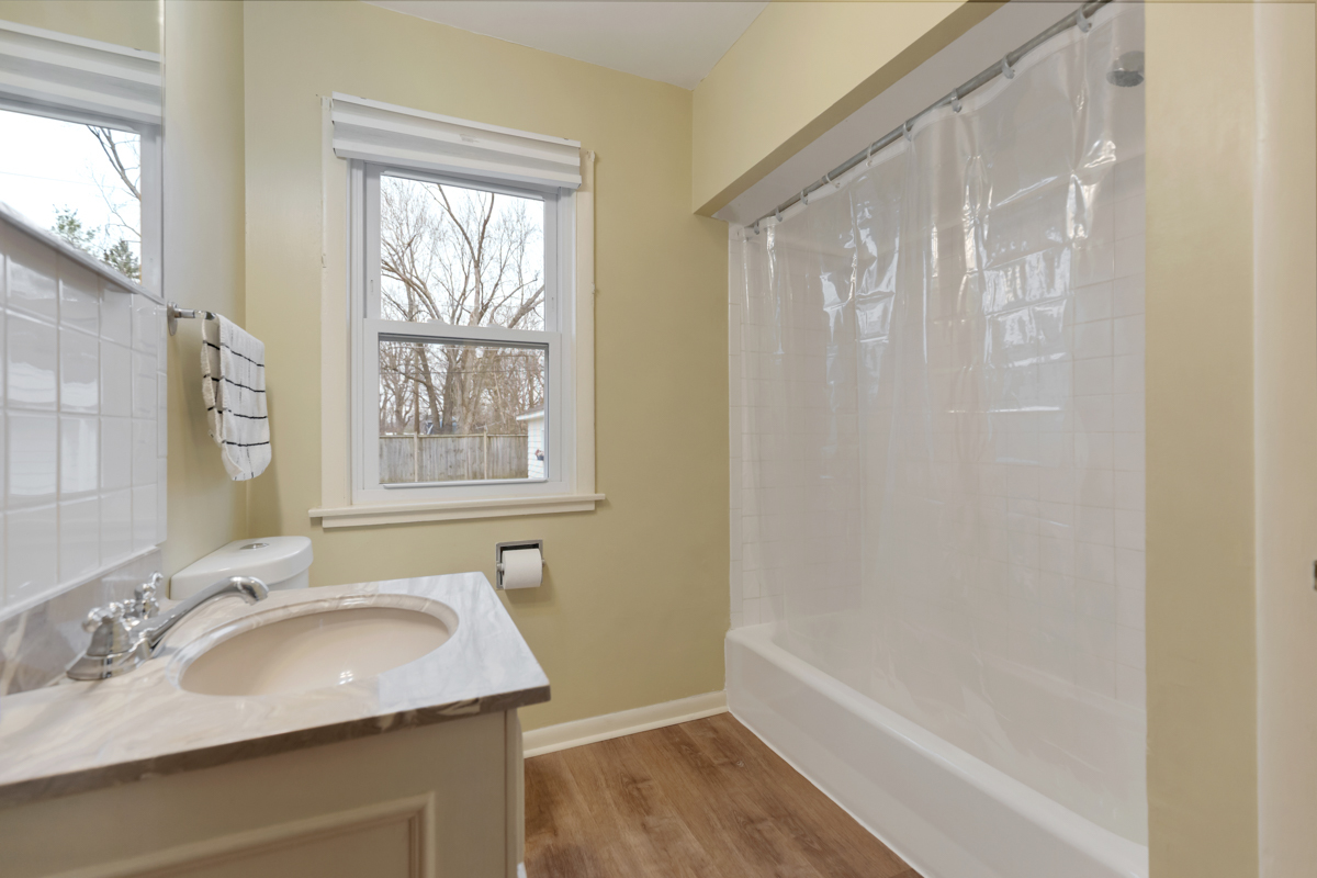 610 High Street Geneva, IL 60134 - Photo 10 of 18 a bathroom with a granite countertop sink a mirror and a bathtub