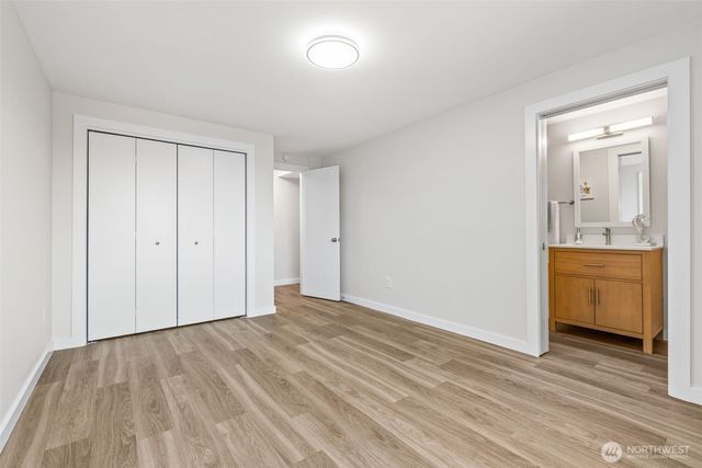 a view of empty room with wooden floor and sink