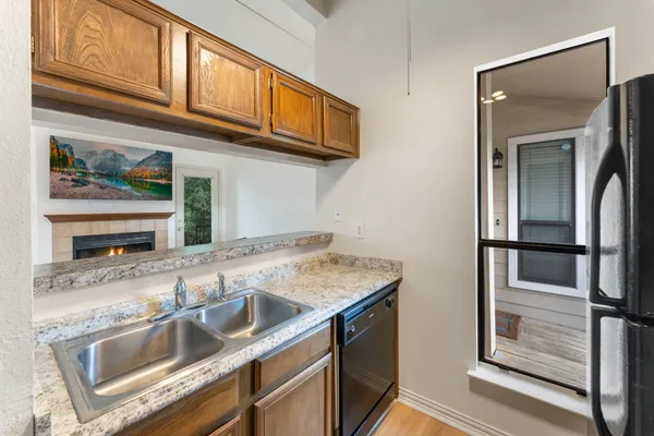 a kitchen with stainless steel appliances granite countertop a sink and a refrigerator