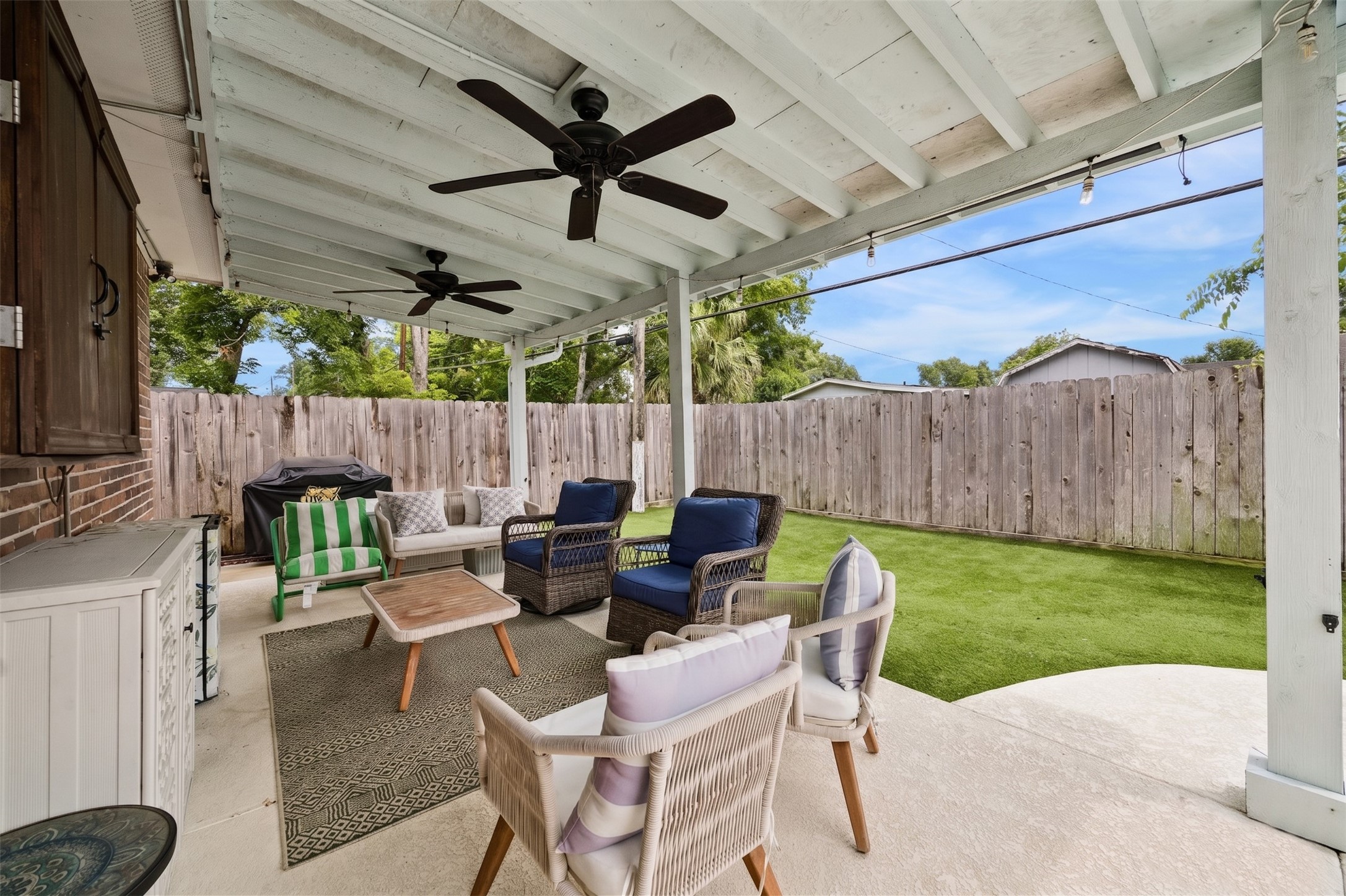 5121 Libbey Drive Houston, TX 77092 - Photo 23 of 24 Step outside to your private outdoor retreat, where a spacious covered patio-complete with overhead fans-offers a refreshing escape from the afternoon sun. Low-maintenance turf provides a vibrant pop of green year-round with minimal upkeep.