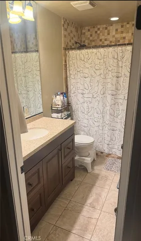 a bathroom with a granite countertop sink a toilet and shower